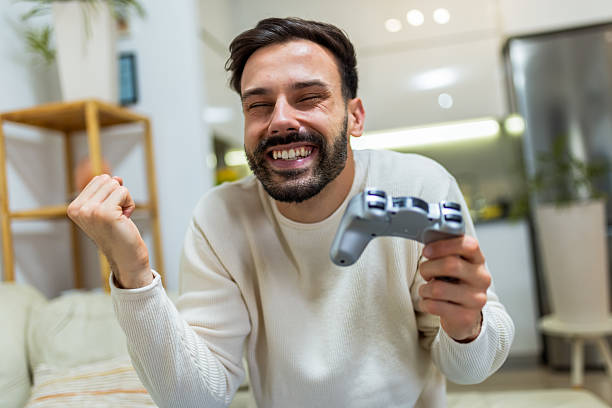 istock A young man playing video games with a joystick in hand. 2213746246
