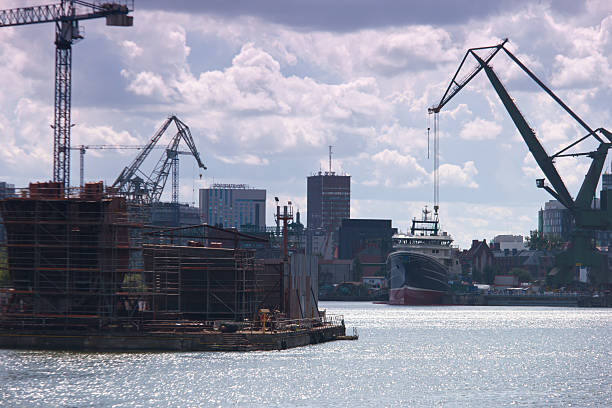 istock Construction and ship activity by the waterfront in a bustling city during the day with clouds in the sky 2213749209