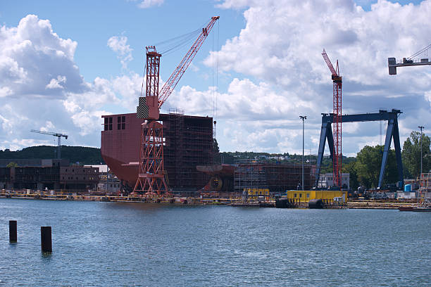 istock Construction of a large ship at a shipyard in bright daylight with cranes and scaffolding present in the background 2213749219
