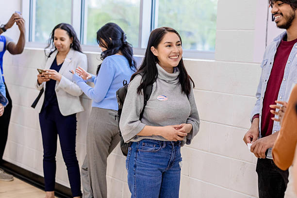 istock Young Latina Woman Smiling After Voting, Multiracial Group 2213749841