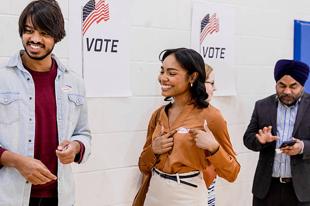 istock Cheerful young woman talks with friends after voting 2213749848