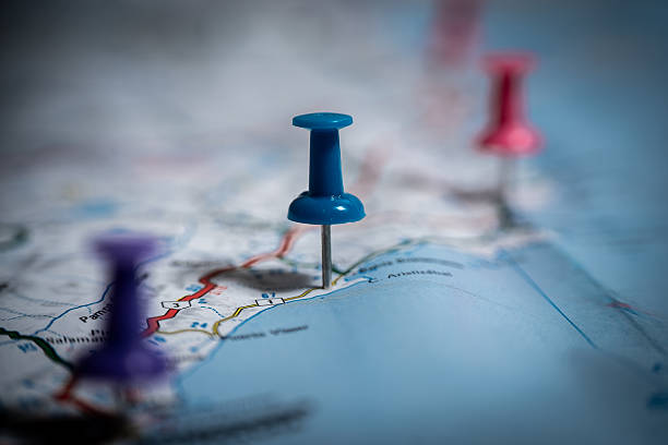 istock Blue push pin marking a location on a map with other pins in the background 2213750086