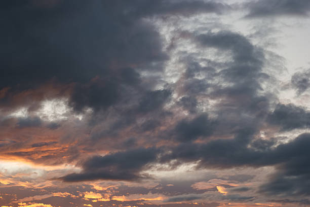 istock Dark clouds gather over the horizon while sunset colors peek through during twilight 2213750424