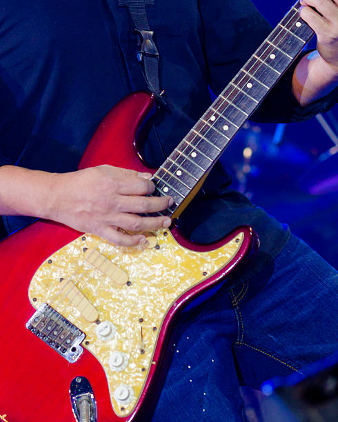 Semi hollow guitar with orange buttons on it. Detailed view of a guitar showcasing its design and texture
