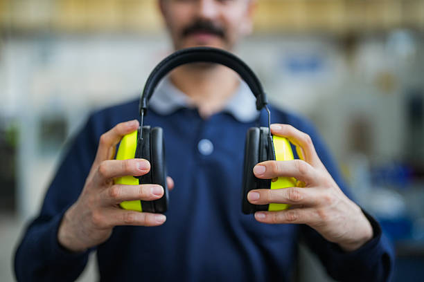 Close-up of a technician holding protective earmuffs for occupational safety