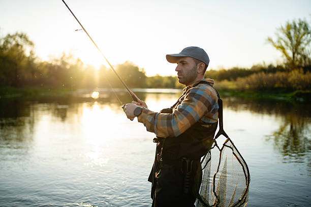 istock Fisherman casting fly line in river at golden hour. 2213753124