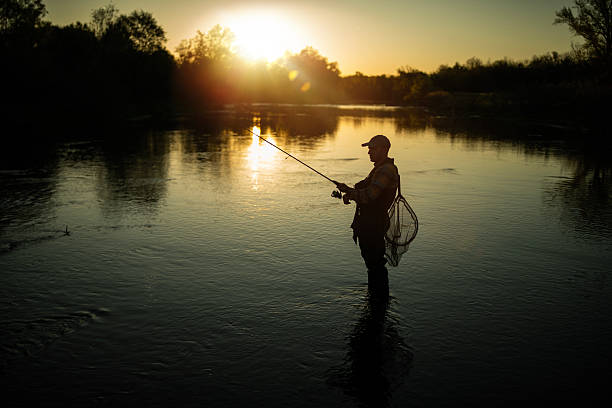 istock Fisherman silhouette in the river at sunset. 2213753128