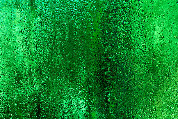 istock wet glass with water droplets. green abstract background 2213754783