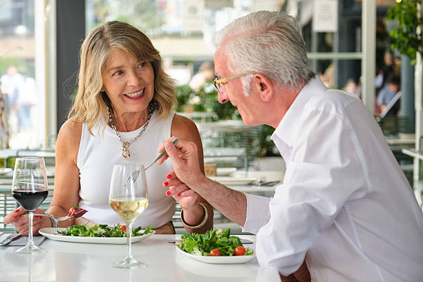 istock Happy retired couple tasting salad and drinking wine at a restaurant 2213756594