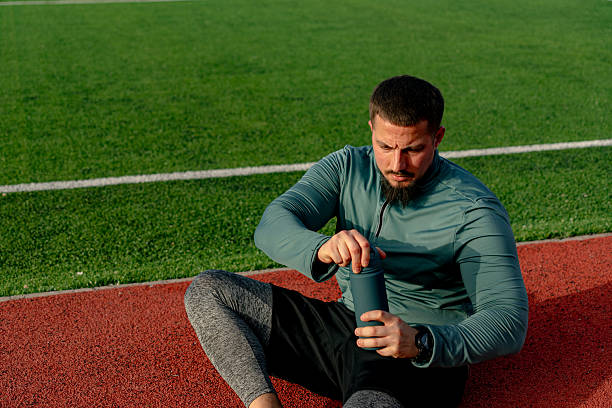 istock Athlete opening his water bottle after training on a running track 2213758070