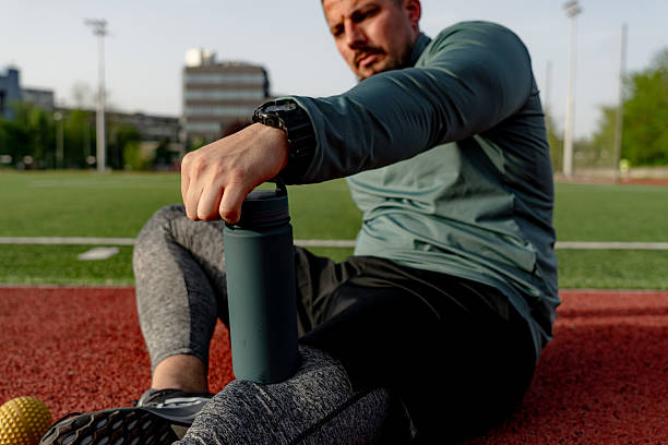 istock Athlete opening his water bottle after training on a running track 2213758085