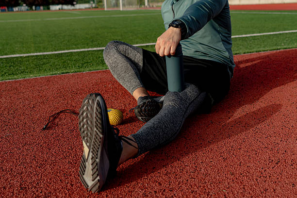 istock Athlete using foam roller for muscle recovery after training on running track 2213758086