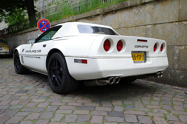 Bad Bentheim, Germany - May 4 2025 A white Chevrolet Corvette C4 is parked beside an old wall. It was an Official Pace Car Indianapolis in 1986. It was on a classic car meeting and parking was allowed