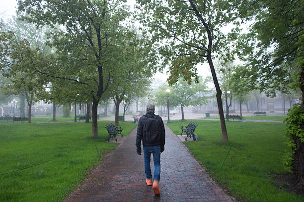 Santa Fe, NM: A man walks across the historic Santa Fe Plaza on a rainy spring morning.