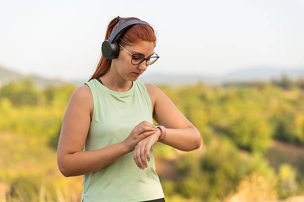 istock Young woman checking smartwatch during outdoor workout 2213763244