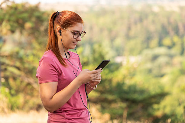 istock Young woman checking smartphone during outdoor workout while taking a break 2213763332