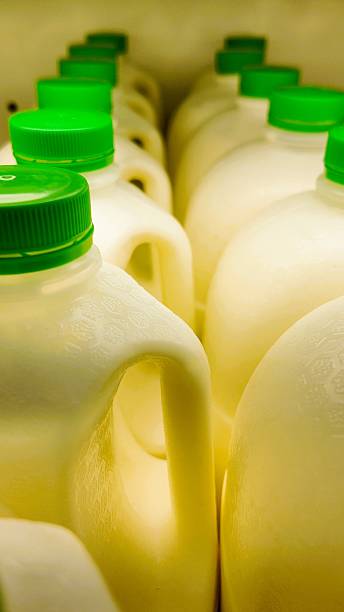 istock Milk Jugs with Green Caps in a Row 2213764107