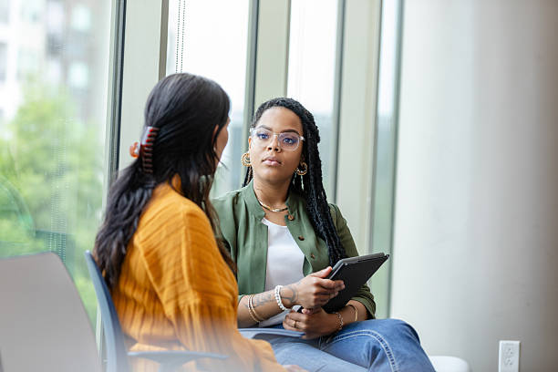 istock Two Diverse Women in Discussion, Serious Conversation, Casual Office Setting 2213764745
