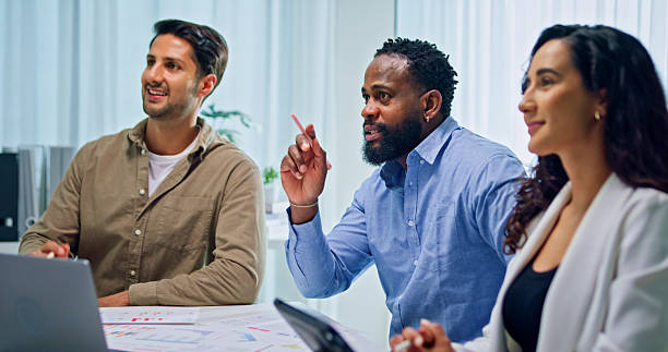 istock Group of business professionals meeting reviewing global data analytics presented on a large screen, discussing strategy and growth at the office. Finance meeting concept. 2213765649