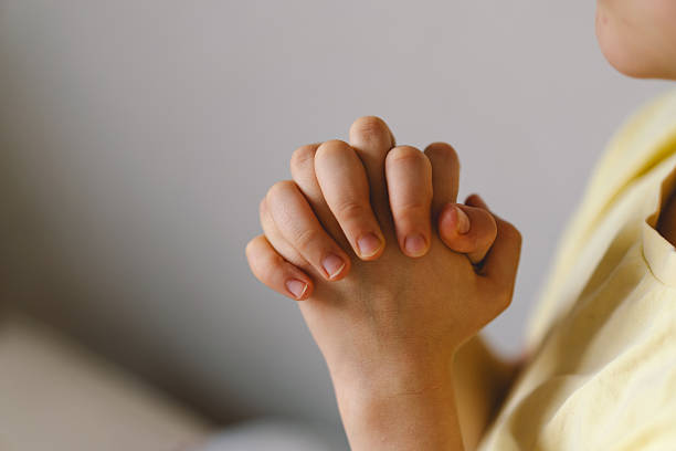 istock A boy with folded hands in front of him, he is praying or meditating 2213766849
