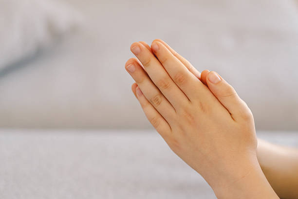 istock A boy with folded hands in front of him, he is praying or meditating 2213767095