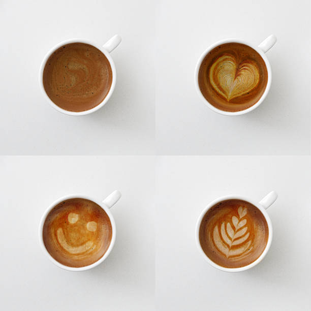 Collection of four coffee cups with various designs made with foam. Top view.