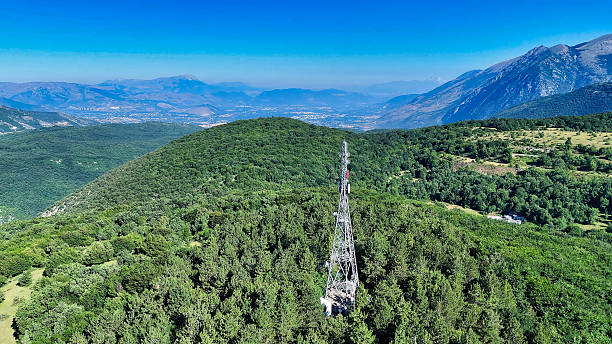 istock Telecommunication tower dominating mountain peak in a vast forest landscape 2213769524
