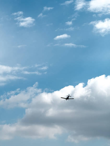 istock Small airplane flying in cloudy sky on sunny day 2213771971
