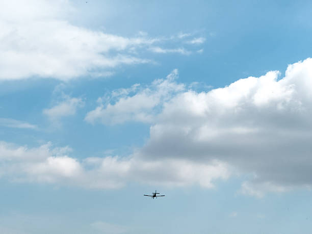 istock Small airplane flying in cloudy sky on sunny day 2213772025