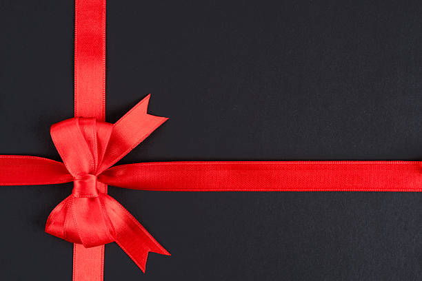 istock Red ribbon and bow on black background 2213772050
