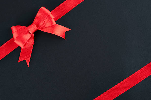 istock Red ribbon and bow on black background 2213772612