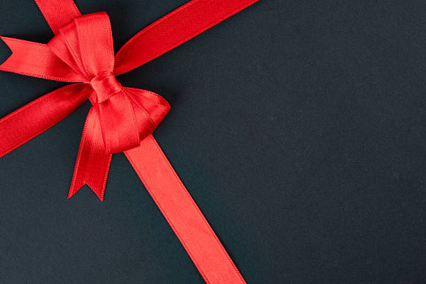 istock Red ribbon and bow on black background 2213772698