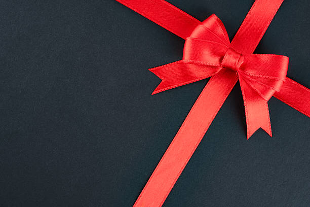 istock Red ribbon and bow on black background 2213772701