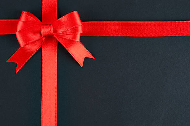 istock Red ribbon and bow on black background 2213772724