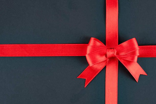 istock Red ribbon and bow on black background 2213772855