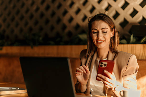 istock Businesswoman smiling and using smartphone in a cafe 2213778449