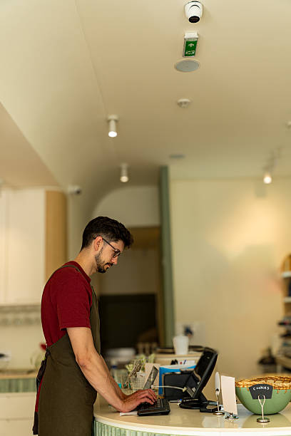 istock Cashier working at the till in a modern coffee shop 2213778708