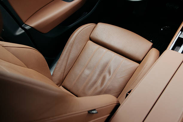 istock Luxurious tan leather car interior featuring perforated seat design and dark accents A premium automotive detail emphasizing comfort 2213779890