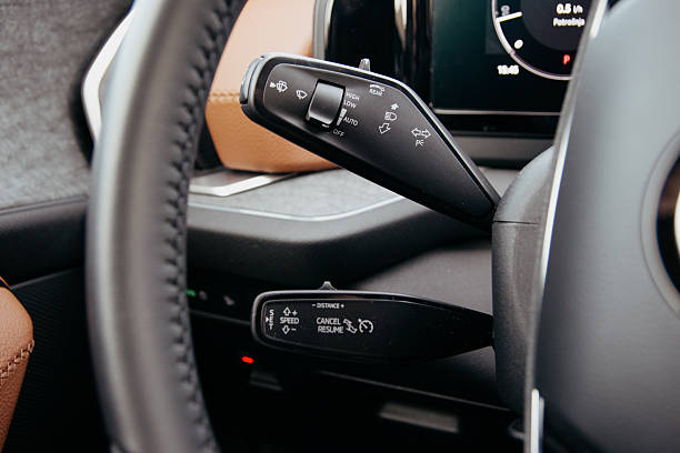 istock Car interior detail: steering wheel and control levers for wipers and cruise control close up view inside the automobile 2213781558