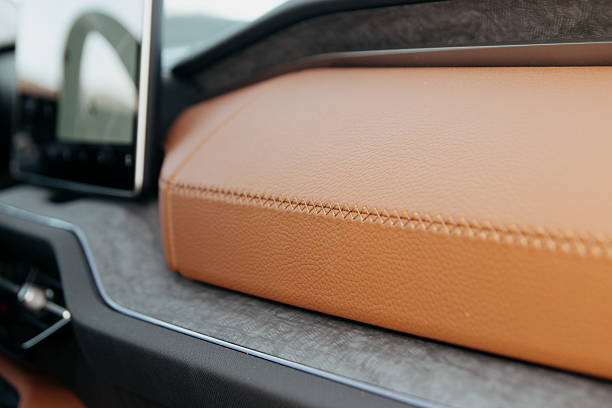 istock Close up of a car's interior featuring a tan leather dashboard with elegant stitching complemented by a digital screen 2213781622