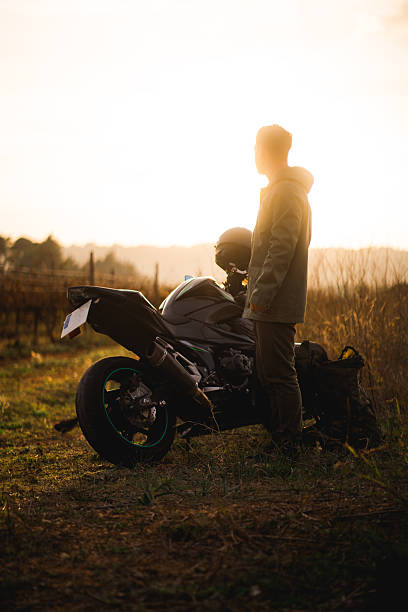 istock Man with motorcycle at sunset 2213785418