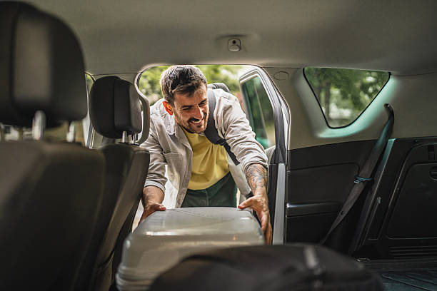 istock Adult man tourist pack and loading luggage baggage into car 2213787331