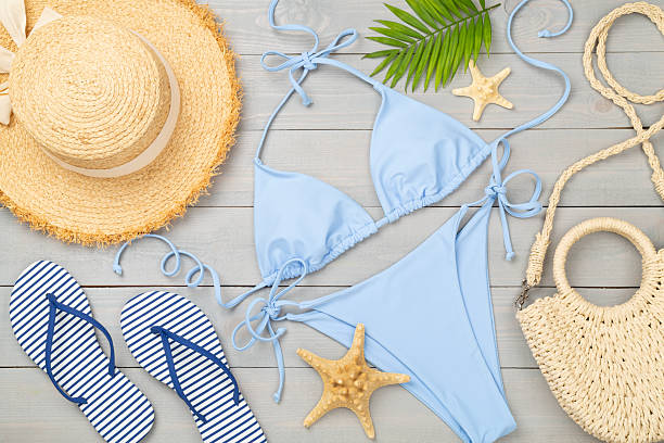 istock Blue bikini with beach accessories on wooden background, top view 2213789968
