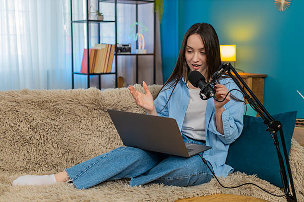 istock Woman blogger happily recording podcast vlog on sofa actively gesturing telling interesting story 2213790146