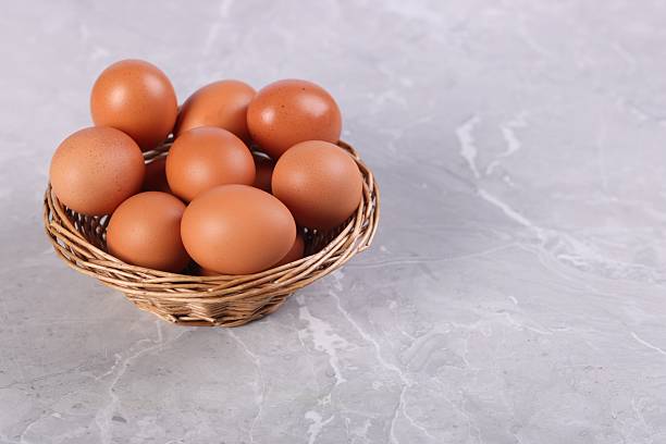 istock Wicker basket with fresh eggs on grey marble table, closeup. Space for text 2213792647