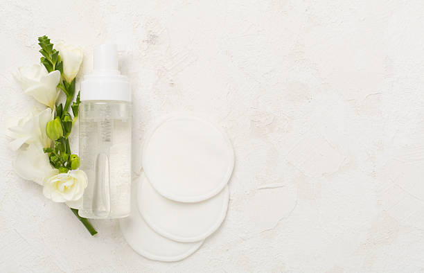 istock Cosmetic bottle with flowers on concrete background, top view 2213792987