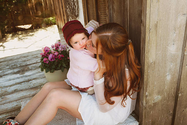 A beautiful mother with her precious baby daughter. The baby is five months old. Shot with a Canon 5D Mark IV.