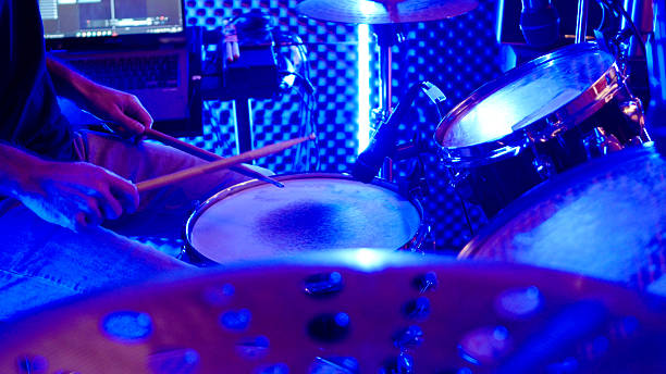 Music band rehearsal in recording studio with blue & purple neon lights. Dedication & passion of musicians as they practice their craft, intense creative exploration.