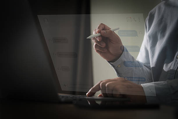 istock contact us Close up Man using smart phone chatting  contact us his office desk using a laptop computer global internet networking, social media 2213802650