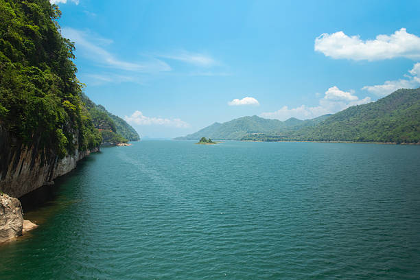 Water surrounded by mountains and bright blue sky in Tha Khanun, Kanchanaburi, Thailand